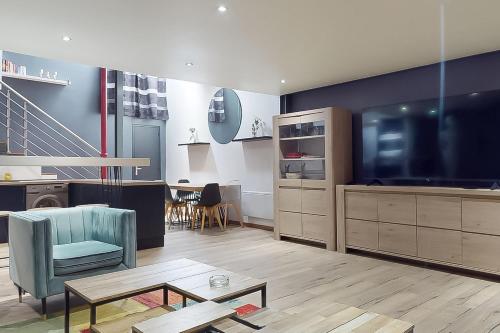 un salon avec une grande télévision à écran plat dans l'établissement Loft cosy, à Suresnes