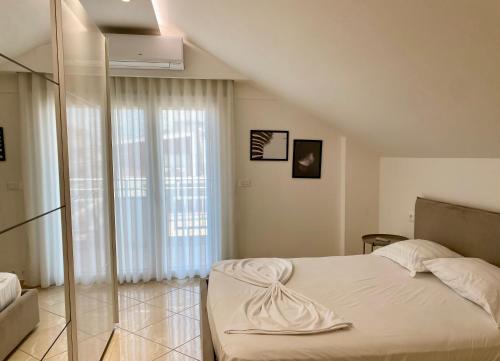 a bedroom with a bed and a large window at Lovely Rooftop Apartment in Golem