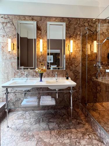 a bathroom with two sinks and a shower at Hôtel Bristol Pau in Pau