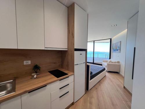 a kitchen with white cabinets and a view of the ocean at Beachfront Marilyn in Durrës