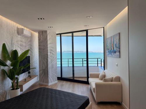 a living room with a couch and a view of the ocean at Beachfront Marilyn in Durrës