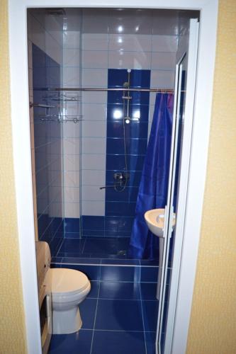 a blue tiled bathroom with a toilet and a sink at orbi plaza in Batumi