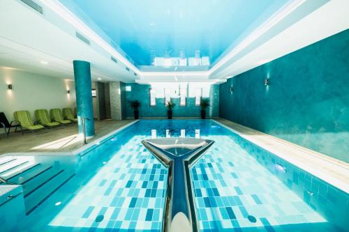 a swimming pool with blue tiles on the floor at Wellness Hotel Panorama in Trenčianske Teplice