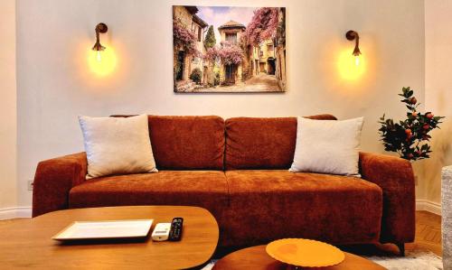 a living room with a brown couch and a table at Sicilia luxury Suite By Sattal in Bucharest