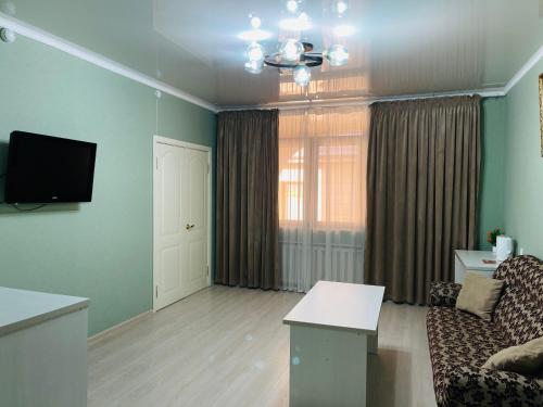 un salon avec un canapé et une télévision à écran plat dans l'établissement Green Hotel, à Tachkent