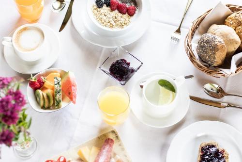 a table with breakfast foods and drinks on it at Hotel Baumwirt in Castelrotto