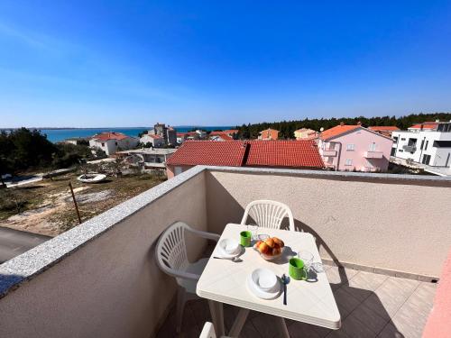 a white table and chairs on a balcony with a view at Apartmani Dorana in Vrsi