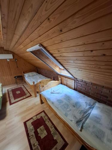 a room with two beds in a wooden cabin at Szőlő Vendégház Balatongyörök in Balatongyörök
