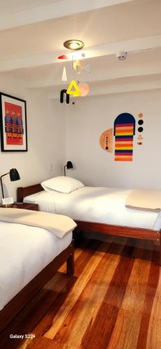 a room with two beds and a surfboard on the wall at Solara Art Hotel by Amak in Cusco