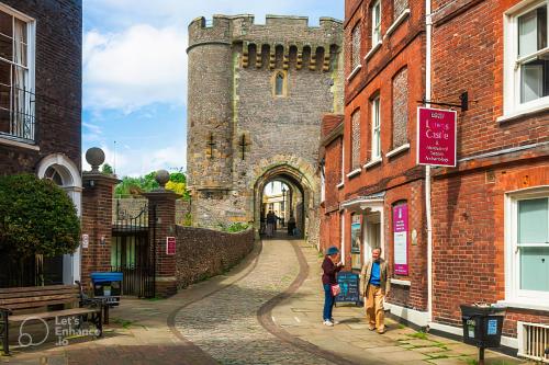 two people walking down a street in front of a castle at Elegant Double Room in Historic Georgian Lewes Townhouse in Lewes