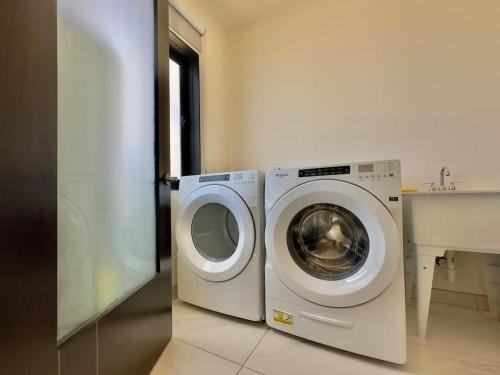 y baño con lavadora y lavadora. en Luxury Beachfront Condo 3BR 3BA with stunning views, en Tijuana