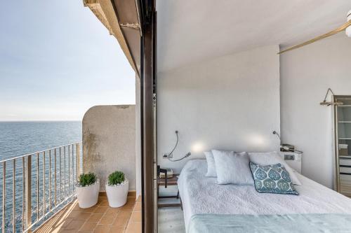 a bedroom with a bed and a balcony with the ocean at Exclusivo Loft En Cap Sa Sal in Begur