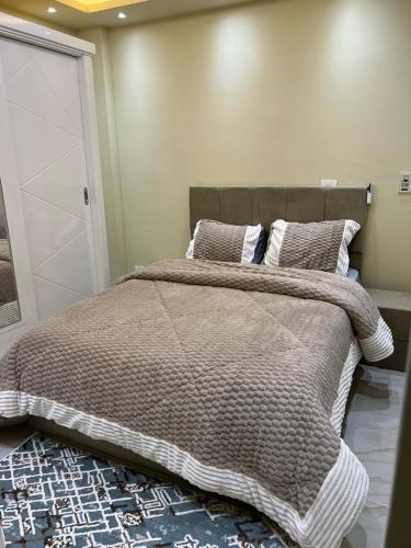 a bedroom with a large bed and a closet at marhaba madinaty 34 in Madinaty