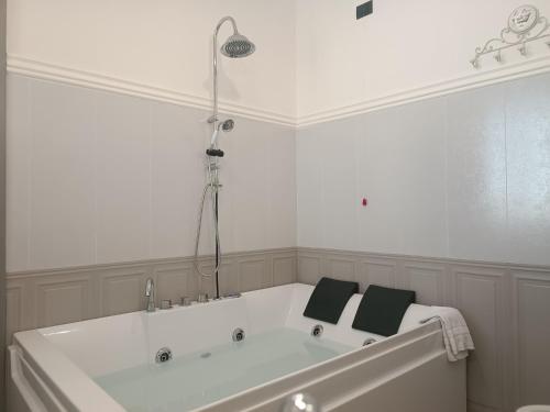a white bath tub with two black towels on it at Relais Tiaré Bed and Breakfast in Bacoli