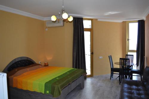 a bedroom with a bed with a colorful blanket at orbi plaza in Batumi