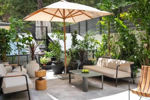 a patio with chairs and an umbrella at master Mazeh in Tel Aviv