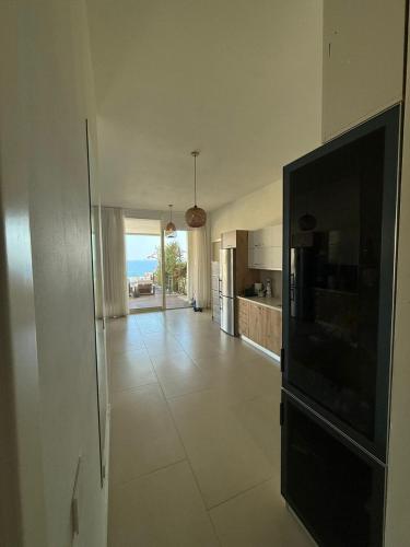 a large living room with a television and a kitchen at Calma View Apartment Green Coast in Palasë