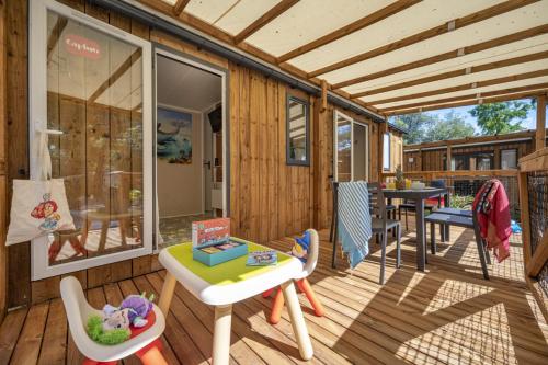 a house with a deck with a table and chairs at Vakantiepark het Wieskamp in Henxel