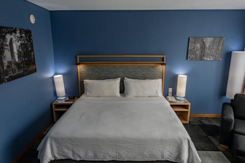 a bedroom with a bed with blue walls and two lamps at Holiday Inn Express Mexico Reforma by IHG in Mexico City
