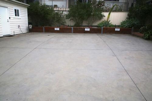 a large concrete parking lot next to a house at 2BR Wollongong Home 10mins walk to Hospital & Train Station with Free Parking and Fast Wi-Fi in Wollongong