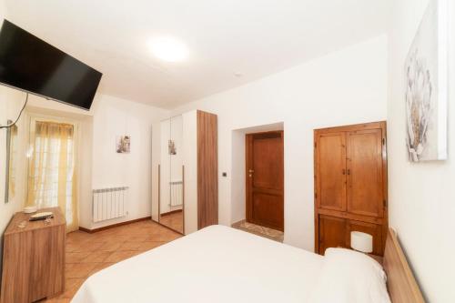 a bedroom with a white bed and a wooden cabinet at Il Girasole in Montefiascone