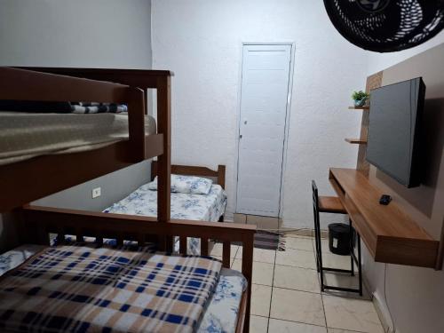 a bedroom with a bunk bed and a desk with a television at Hostel gru Airport in Guarulhos