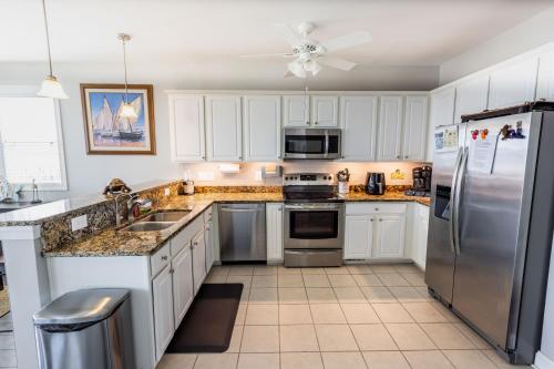a kitchen with white cabinets and stainless steel appliances at Relax,Fish,Grill,Chill! Pup,Kid Friendly Riverfront Paradise! Amenities,Gameroom in Sneads Ferry