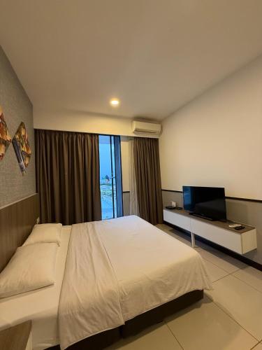 a bedroom with a large bed and a television at PD DWharf Hotel Suite & Serviced Residence in Port Dickson