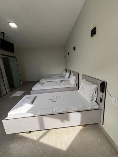 two beds in a room with white sheets and pillows at Singular hotel in Sao Paulo