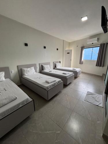 a room with three beds and a tv in it at Singular hotel in Sao Paulo