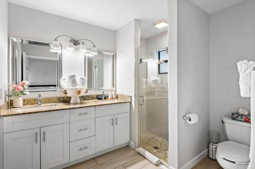 a white bathroom with a sink and a shower at Hot Tub Salt Pool Png Png 5 Min to AtlAv Trampline in Delray Beach