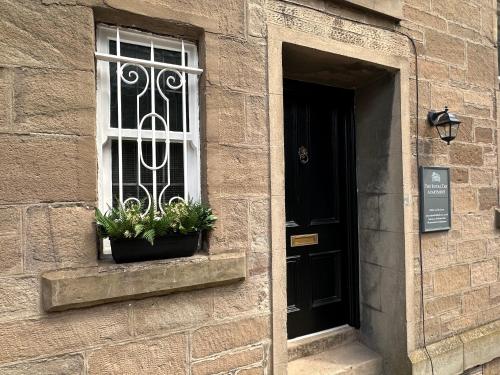 a window of a building with two plants on it at The Royal Tay Apartment in Dundee