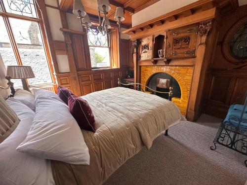 Un dormitorio con una cama y una chimenea. en The Royal Tay Apartment, en Dundee