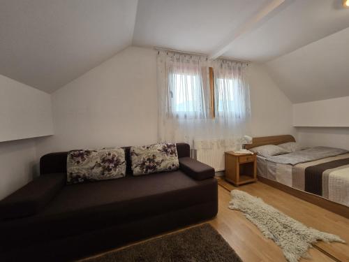 a living room with a couch and a bed at Pensiunea Casa Madalina in Corbeni