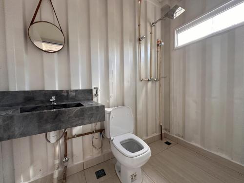 a bathroom with a toilet and a sink and a mirror at Casa Villela na Villela Home Stay Lago Sul in Brasilia