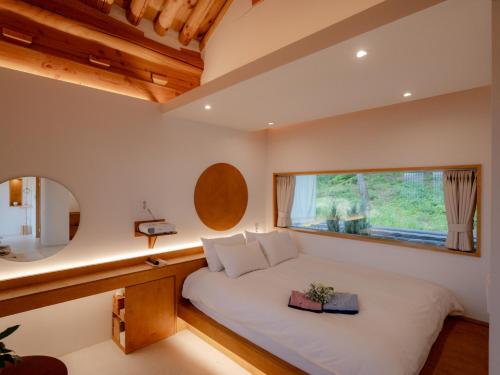 a bedroom with a large white bed with a window at Hanok Stay Yeoyeo in Gyeongju