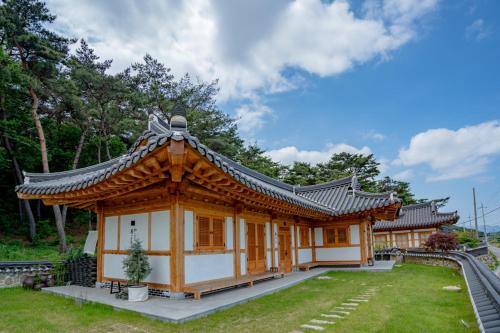 a small building with a roof in a park at Hanok Stay Yeoyeo in Gyeongju