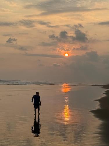 a man walking on the beach at sunset at Villa Macaw in Parrita