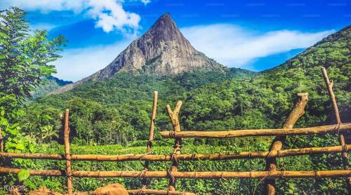 a view of a mountain behind a wooden fence at Mahiyanganaya Holiday Resort in Mahiyangana