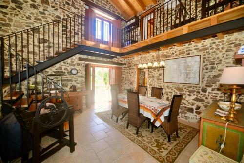 a dining room with a table and a stone wall at Riverside - Lovely river-view 3 bedroom house in Dornes
