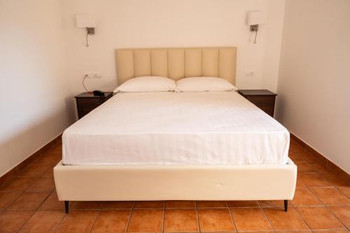 a bedroom with a large white bed with two night stands at Tenuta Madre Vita in Siracusa