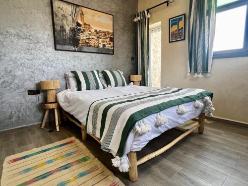 a bedroom with a bed with a striped blanket at Riad La Tempérance in Essaouira