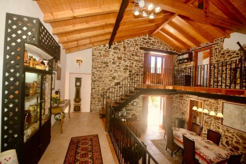 a living room with a staircase and a stone wall at Riverside - Lovely river-view 3 bedroom house in Dornes