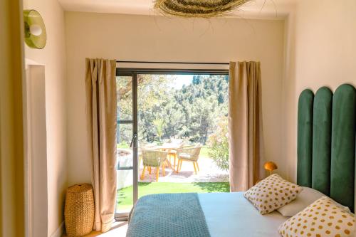 ein Schlafzimmer mit einem Bett und einer Glasschiebetür in der Unterkunft Villa art de vivre & absolute calm Baux de Provence in Les Baux-de-Provence