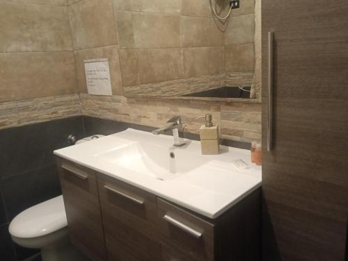 a bathroom with a sink and a toilet and a mirror at Casa Akira Margot in Floridia