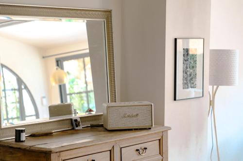 einen Spiegel auf der Kommode in einem Zimmer in der Unterkunft Villa art de vivre & absolute calm Baux de Provence in Les Baux-de-Provence