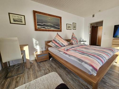 a bedroom with a bed and a picture on the wall at Pension Haus Erika in Cuxhaven