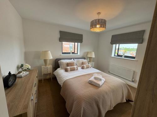 a bedroom with a bed with two towels on it at Uxbridge-Modern 2 bed Apt with Lift & Parking in Uxbridge