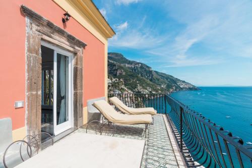 a balcony with chairs looking out over the ocean at Villa Magia in Positano