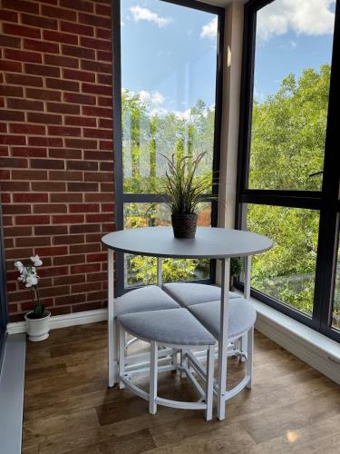 a table and chairs in a room with a window at Uxbridge-Modern 2 bed Apt with Lift & Parking in Uxbridge